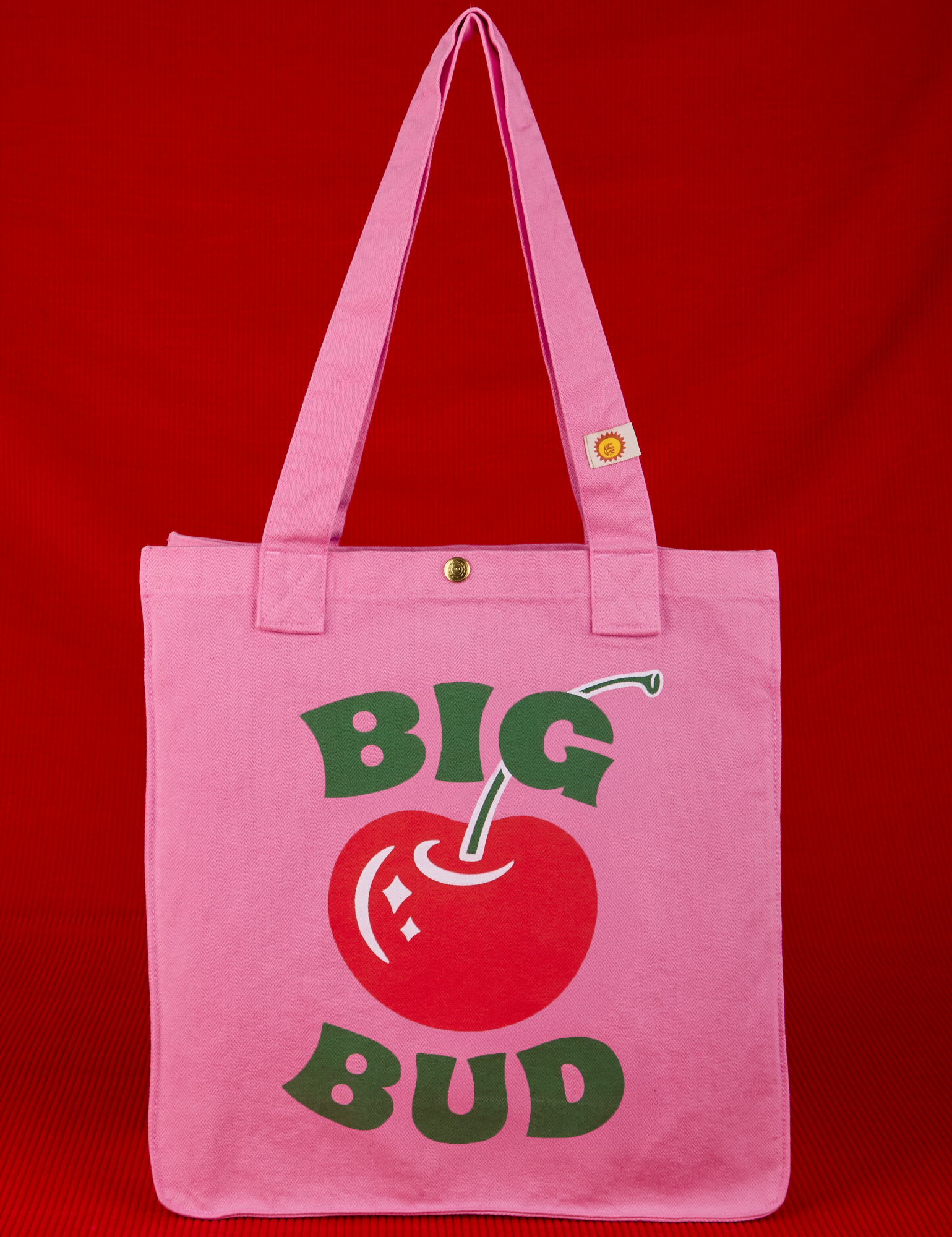Bodega Shopper Tote in Cherry. Pink tote body with screenprinted red cherry and Big Bud in green