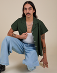 Anthony is wearing Pantry Button-Up in Swamp Green and light wash Wide Leg Trousers