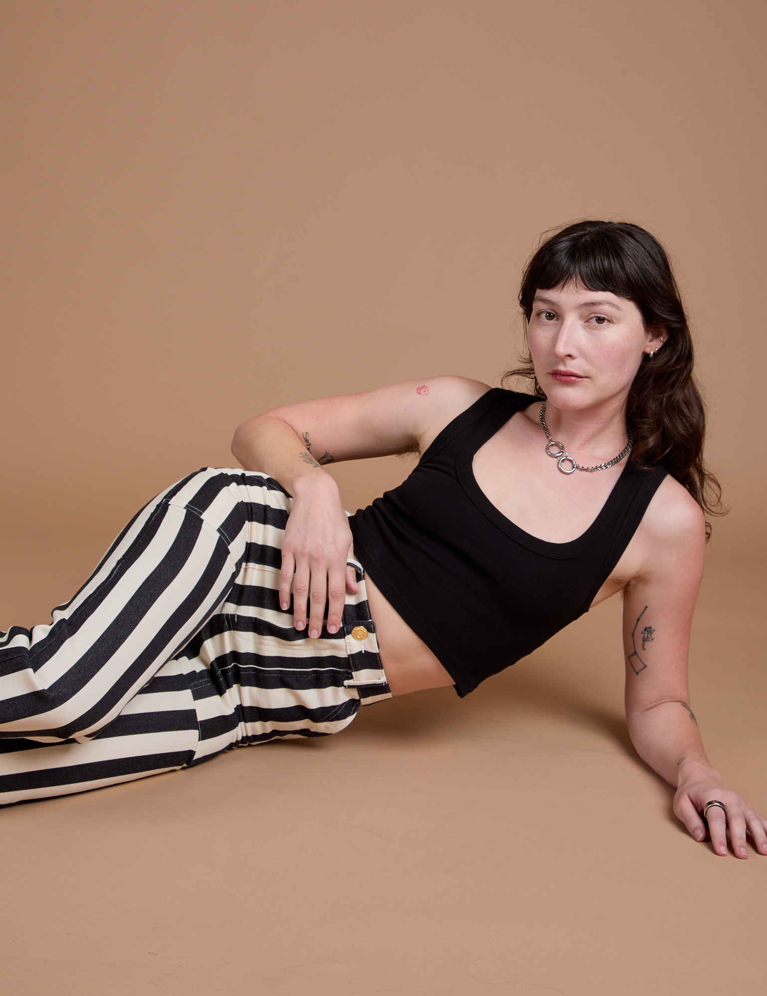 Alex is wearing Black Stripe Work Pants in White and black Cropped Tank