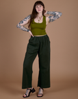 Sydney is wearing Action Pants in Swamp Green paired with olive green Cropped Tank