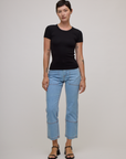 Alex is wearing  Baby Tee in Basic Black and light wash carpenter jeans