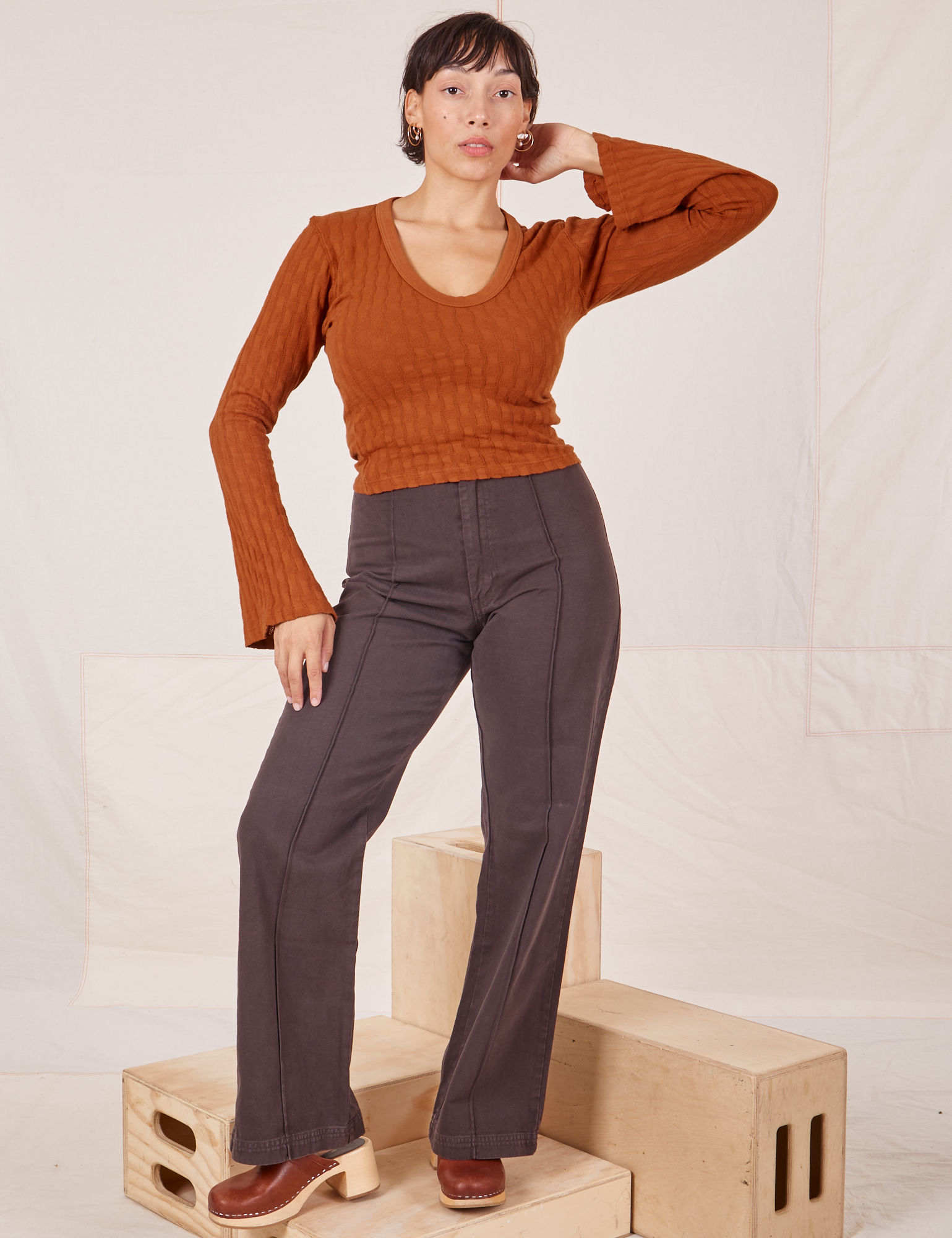 Tiara is wearing S Bell Sleeve Top in Burnt Terracotta paired with espresso brown Western Pants