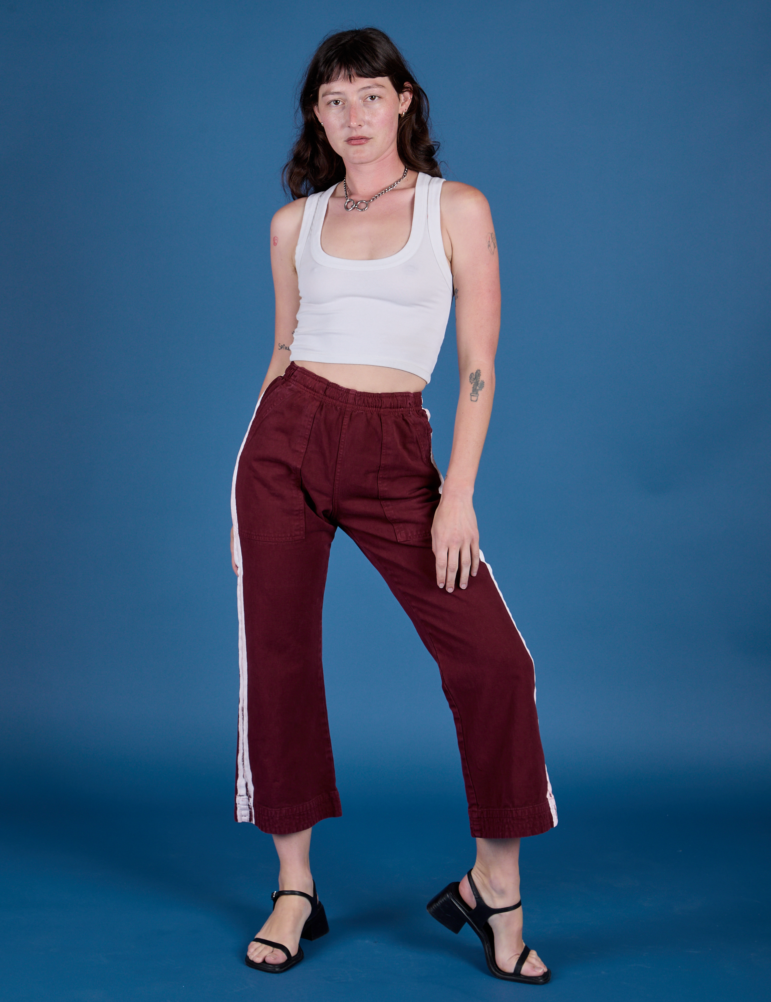 Alex is 5’8” and wearing XXS Painted Action Pants in Red Wine paired with vintage tee white Cropped Tank