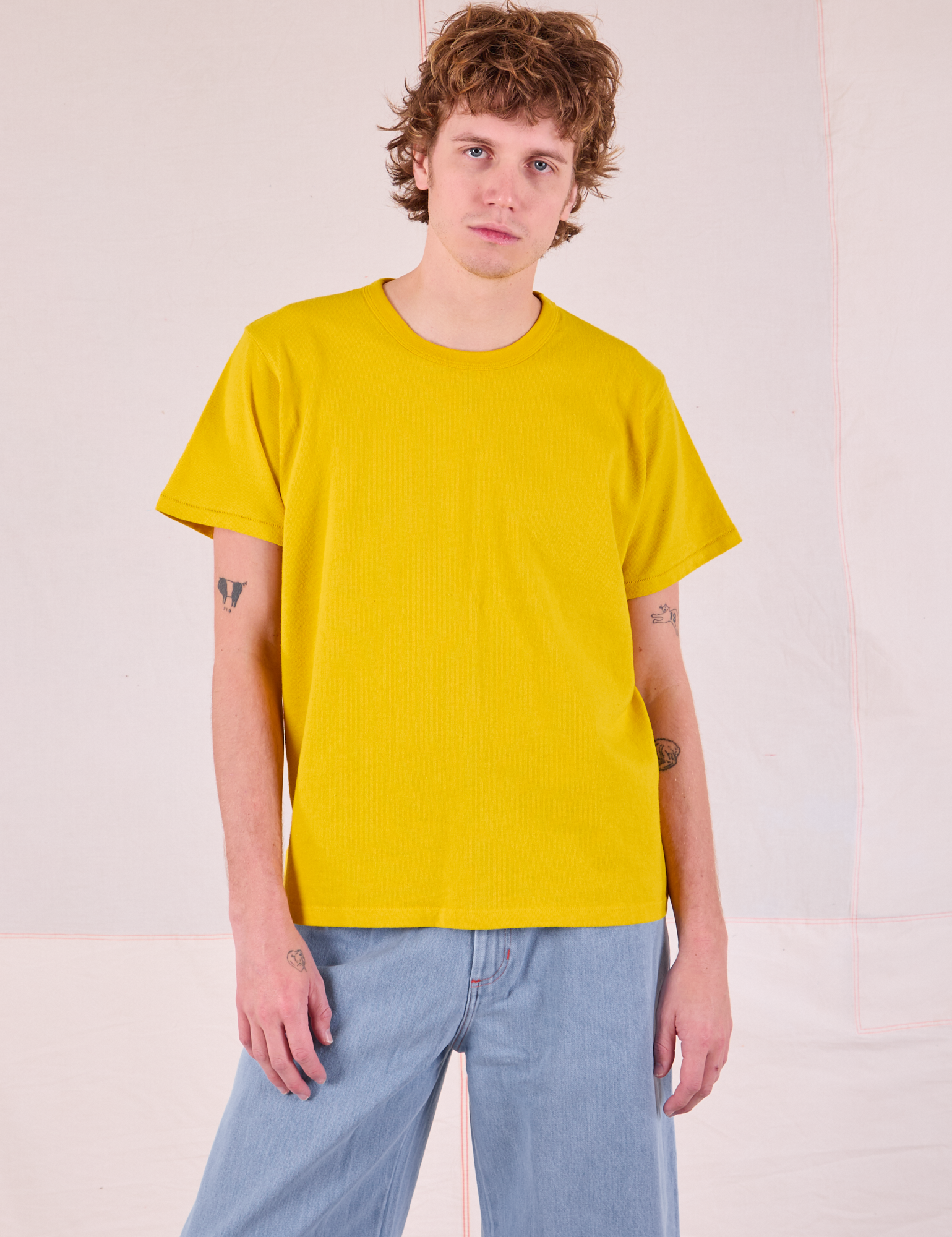 Quinn is 6'3" and wearing S Burly Tee in Golden Yellow