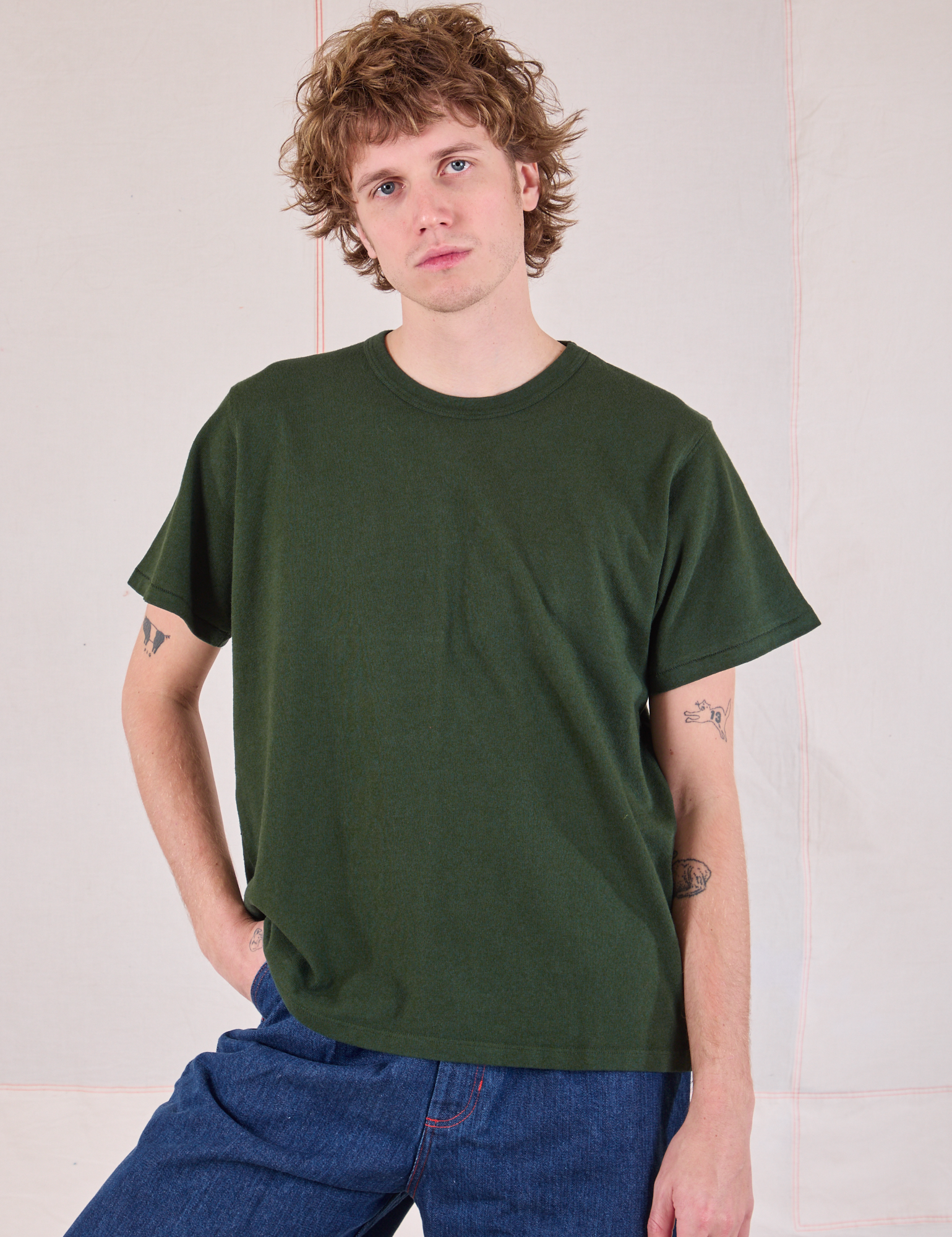 Quinn is 6'3" and wearing S Burly Tee in Swamp Green