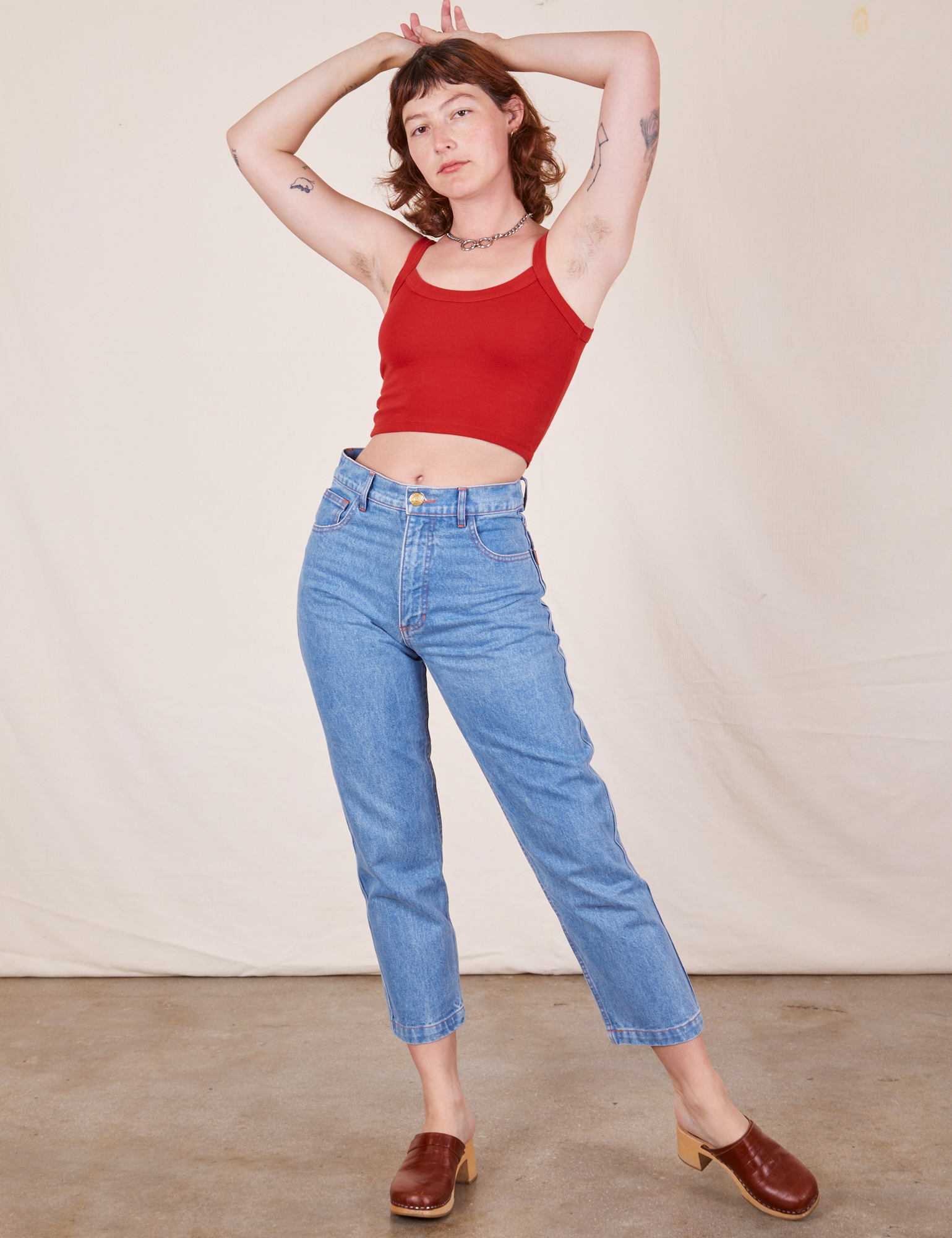 Alex is 5&#39;8&quot; and wearing P Cropped Cami in Mustang Red paired with light wash Frontier Jeans