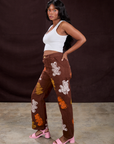 Side view of Gummy Bear Paintstamped Work Pants in Fudgesicle Brown and Cropped Tank in Vintage Tee White on Kandia