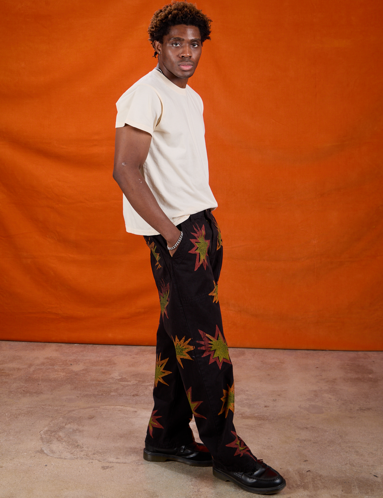 Side view of Paintstamped Work Pants in Explosion and Organic Vintage Tee in Vintage Off-White