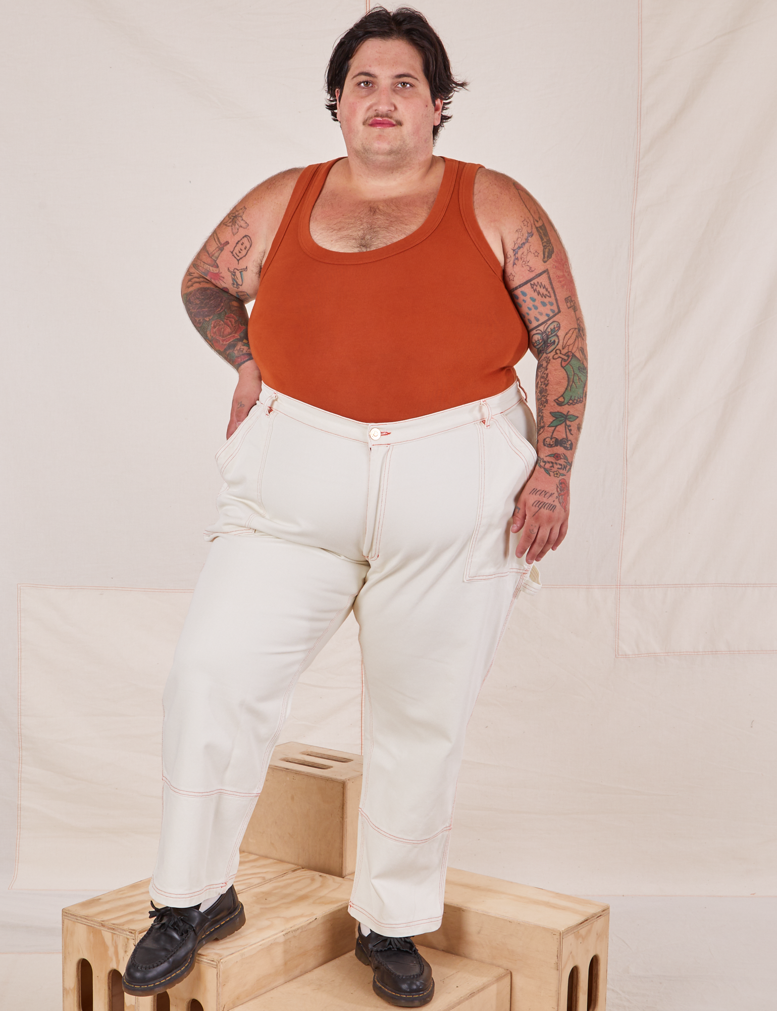 Sam is 5'10" and wearing 3XL Carpenter Jeans in Vintage Off-White paired with burnt terracotta Cropped Tank Top