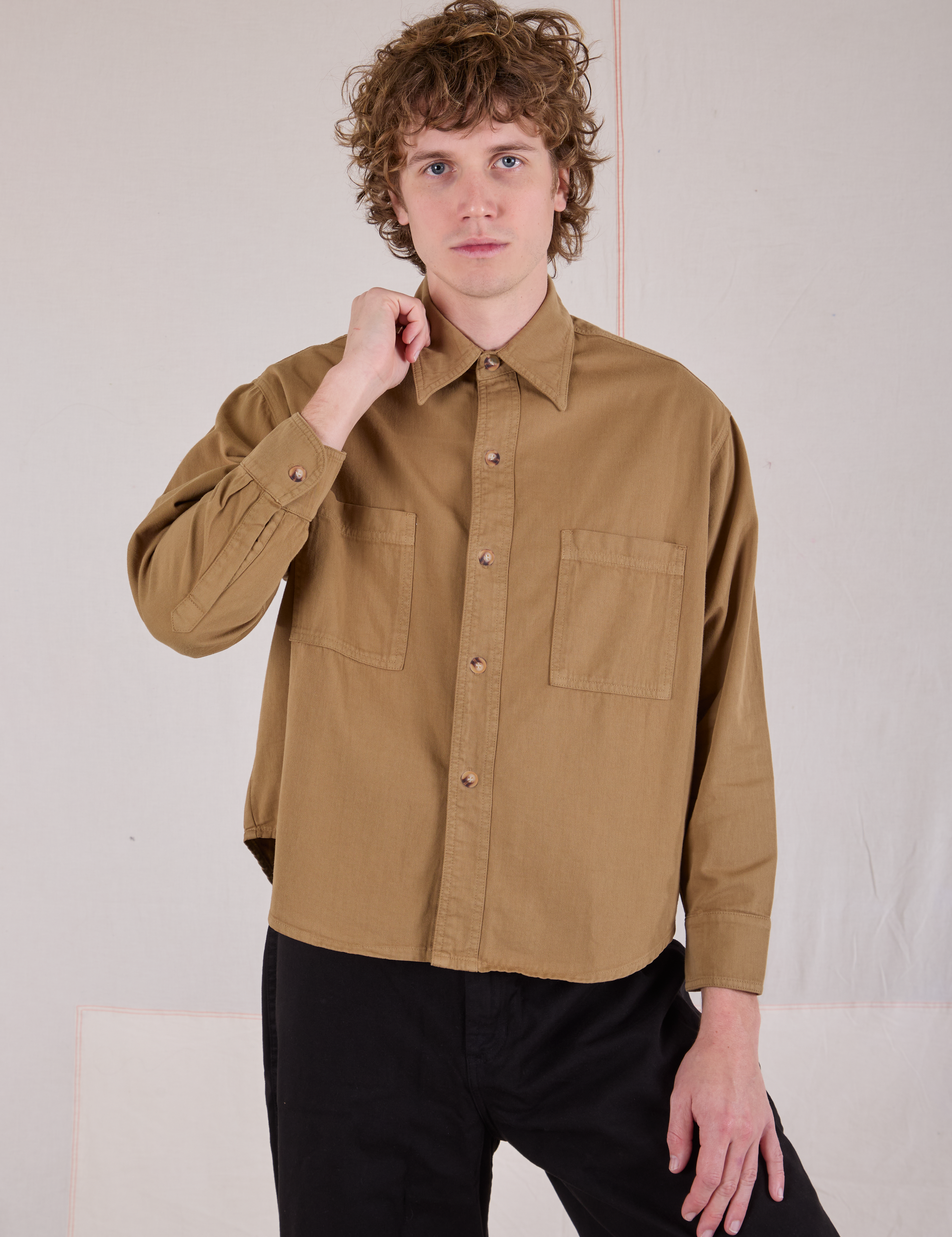 Quinn is wearing a buttoned up Cropped Overshirt in Desert Brown