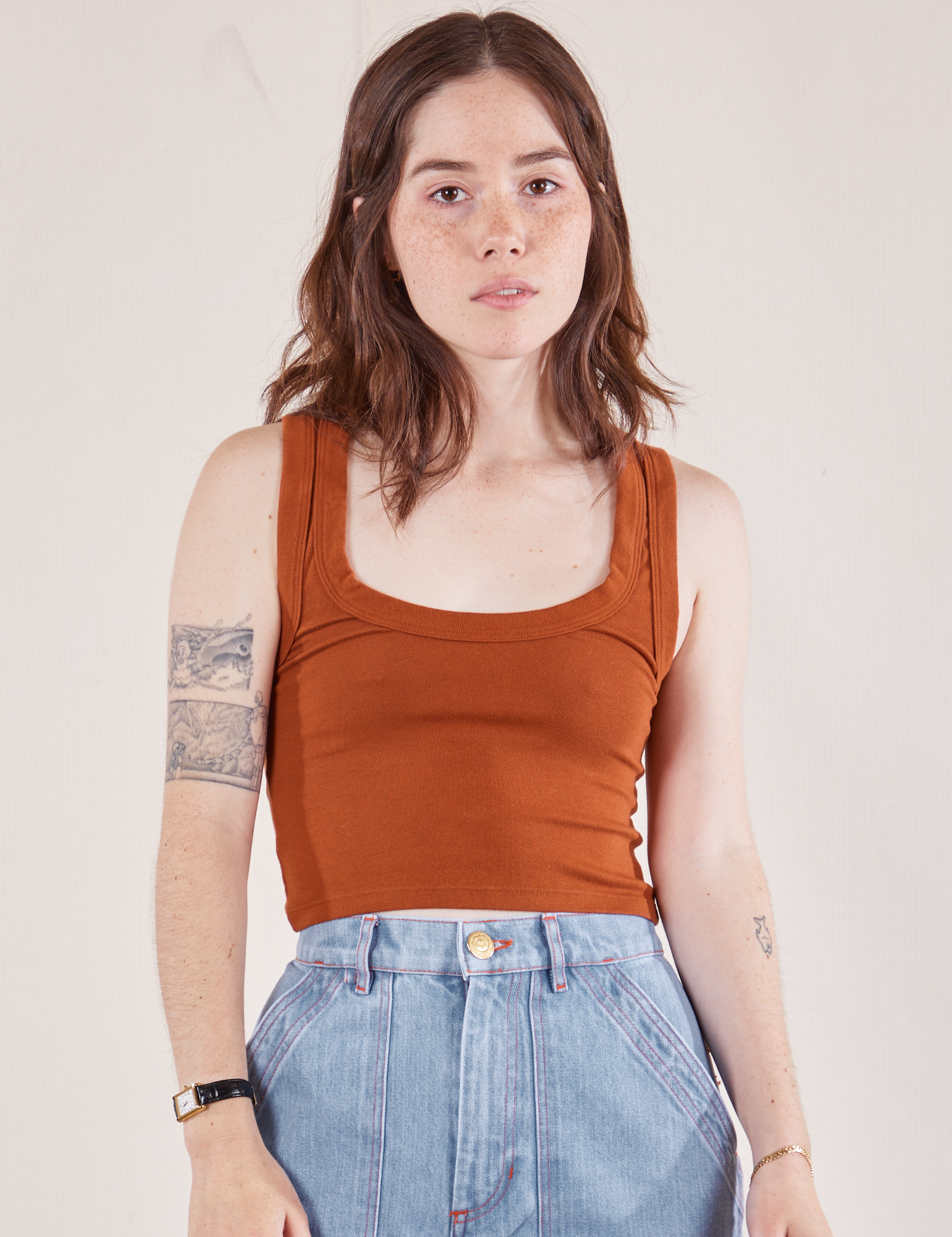 Hana is 5'3" and wearing P Cropped Tank Top in Burnt Terracotta