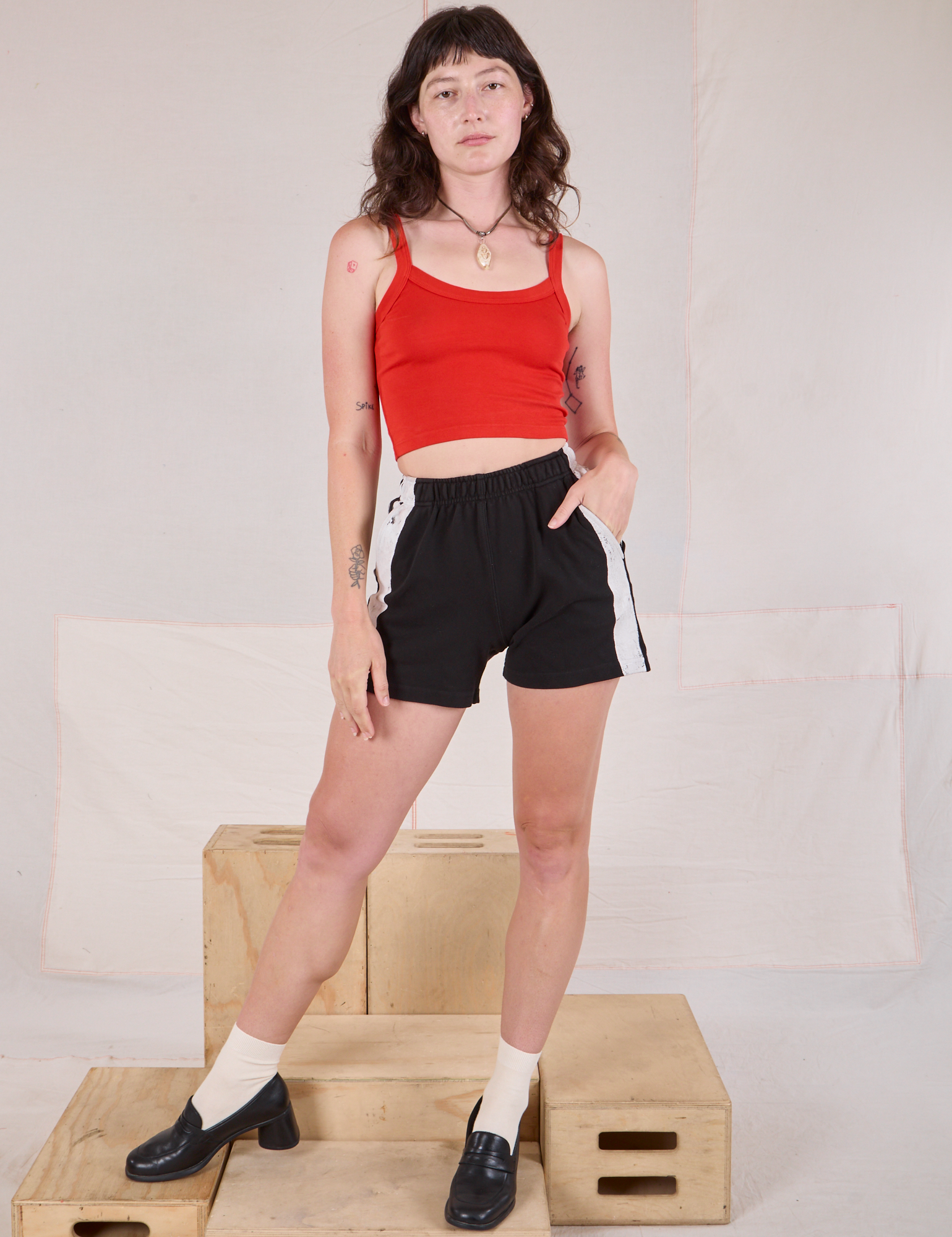 Alex is 5'8" and wearing size P Painted Stripe Easy Shorts in Basic Black paired with mustang red Cropped Cami