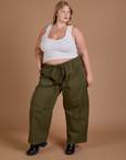 Juliet is 5’7” and wearing 1XL Drop Pocket Cargo Pants in Surplus Green paired with a Cropped Tank in vintage tee white