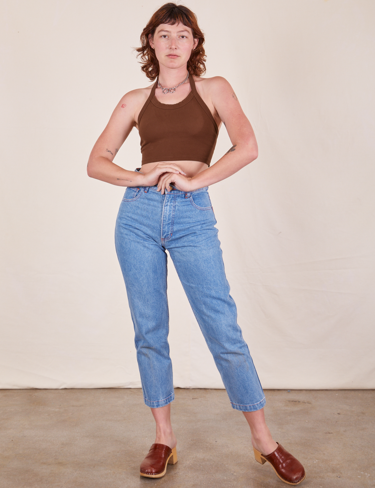 Alex is wearing Halter Top in Fudgesicle Brown and light wash Frontier Jeans 