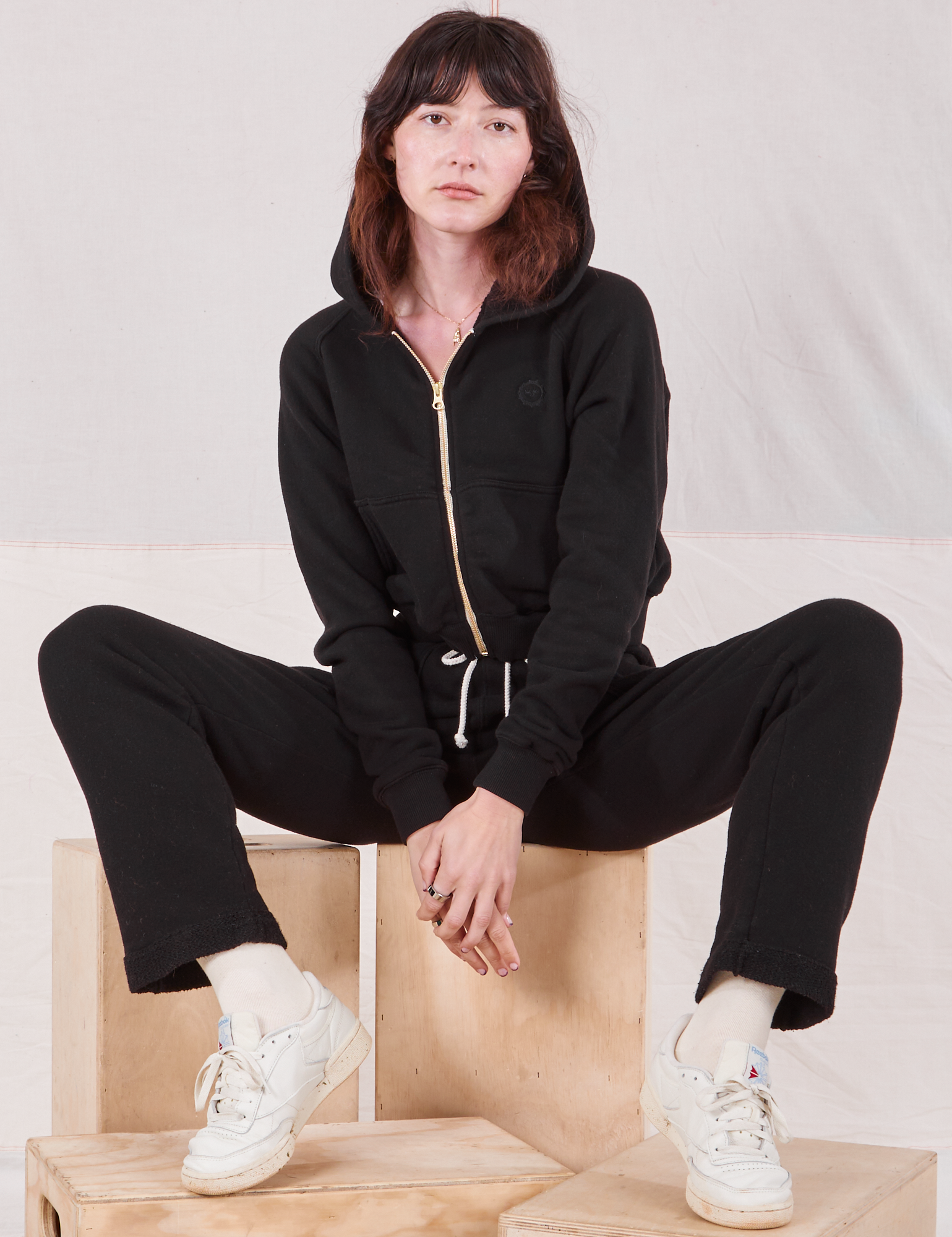 Alex is wearing Rolled Cuff Sweat Pants in Basic Black and matching Cropped Zip Hoodie