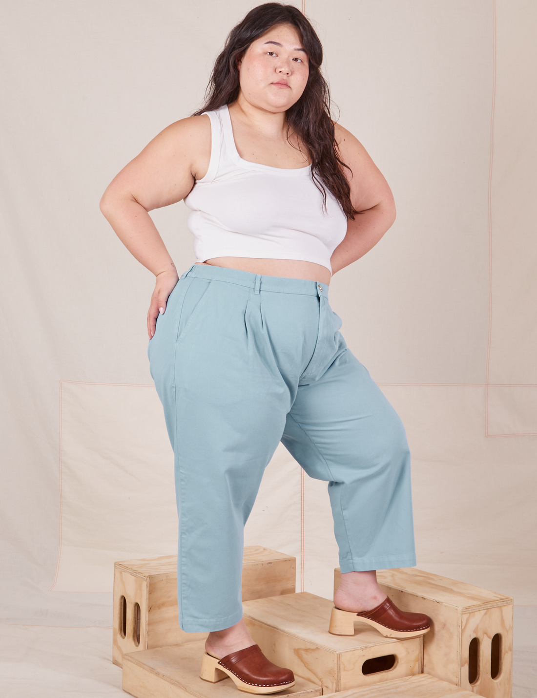Angled view of Heavyweight Trousers in Baby Blue and vintage off-white Cropped Tank Top worn by Ashley