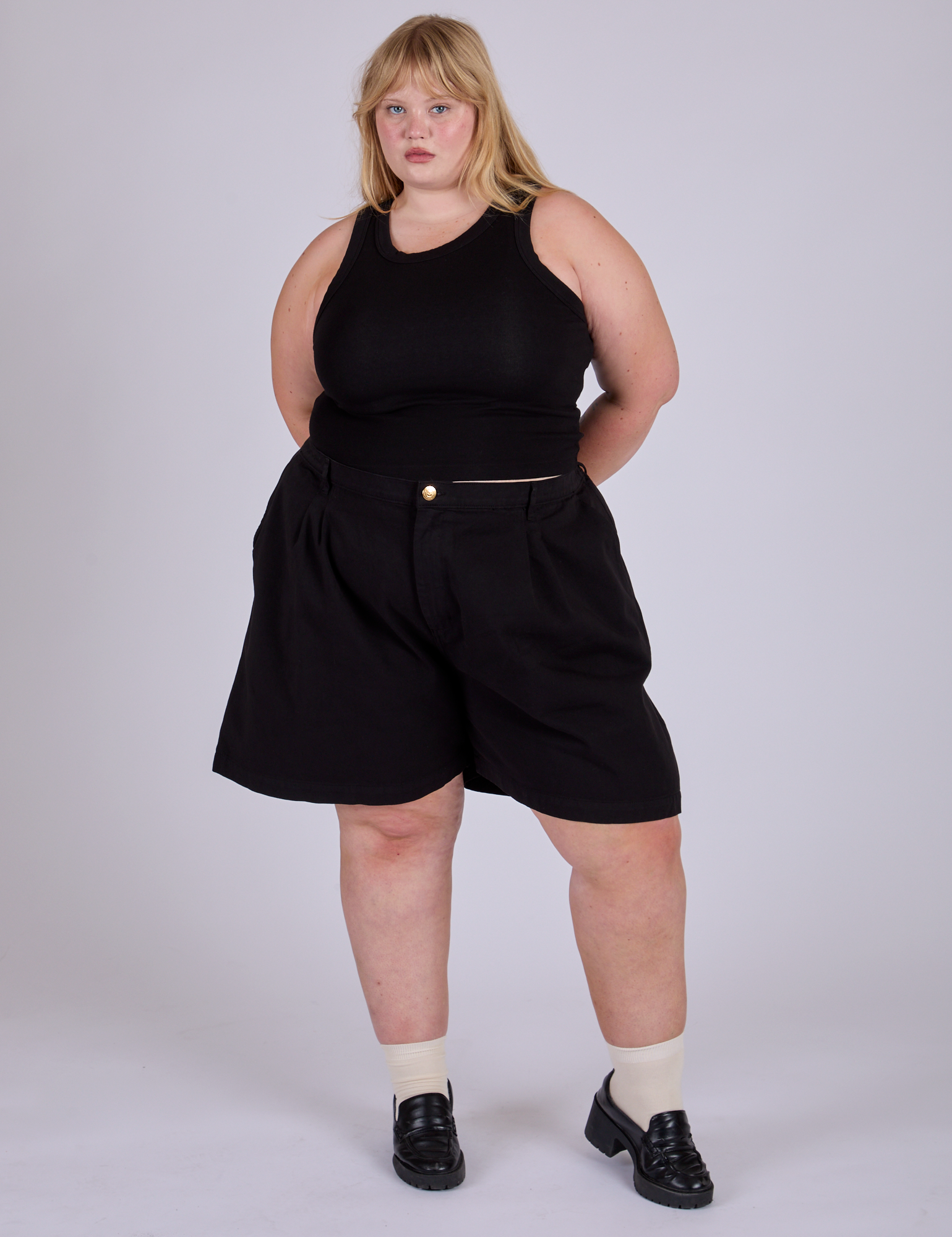 Juliet is wearing Pleated Trouser Shorts in Basic Black and Racerback Tank in Black