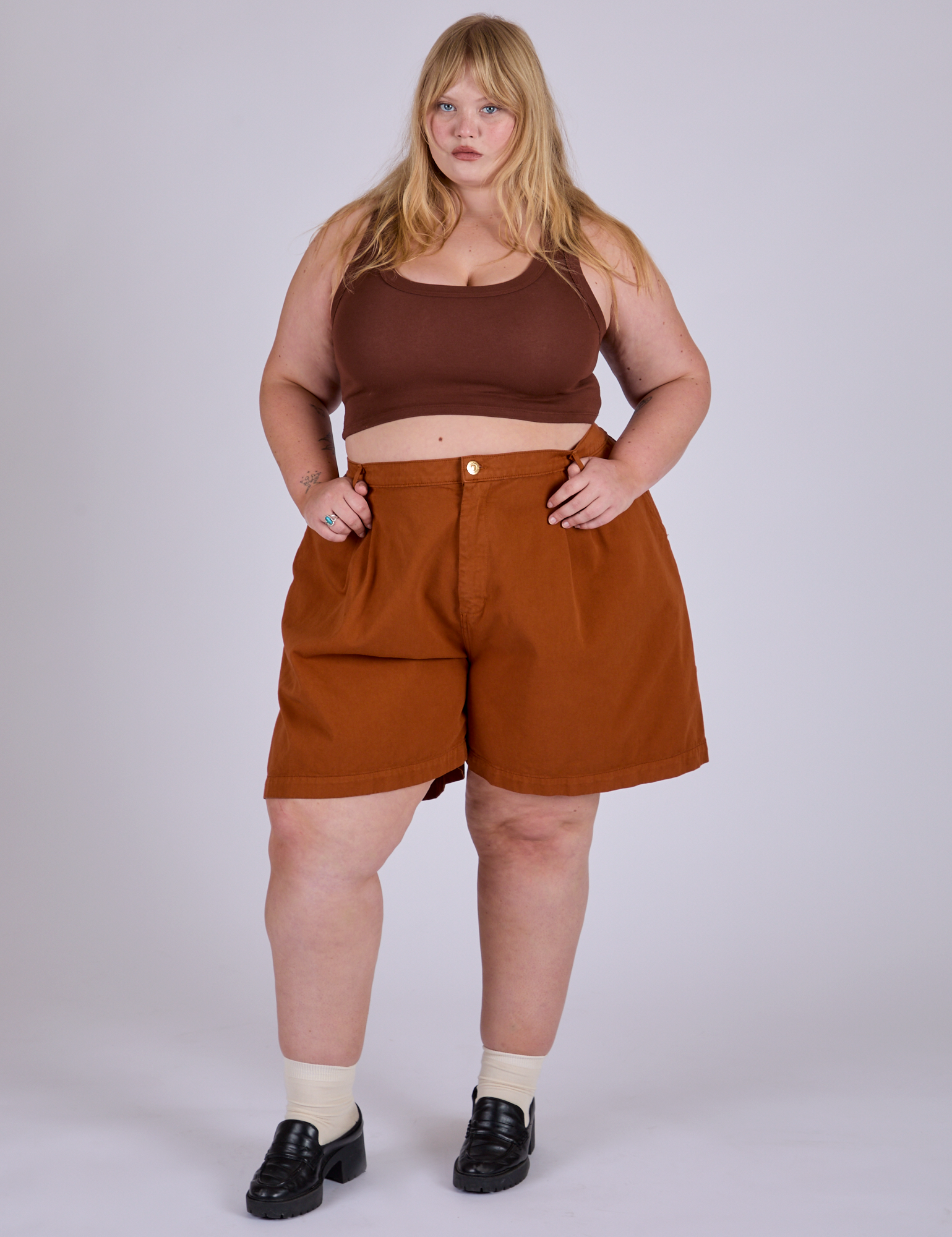 Juliet is wearing Pleated Trouser Shorts in Burnt Terracotta and fudgesicle brown Mini Tank 