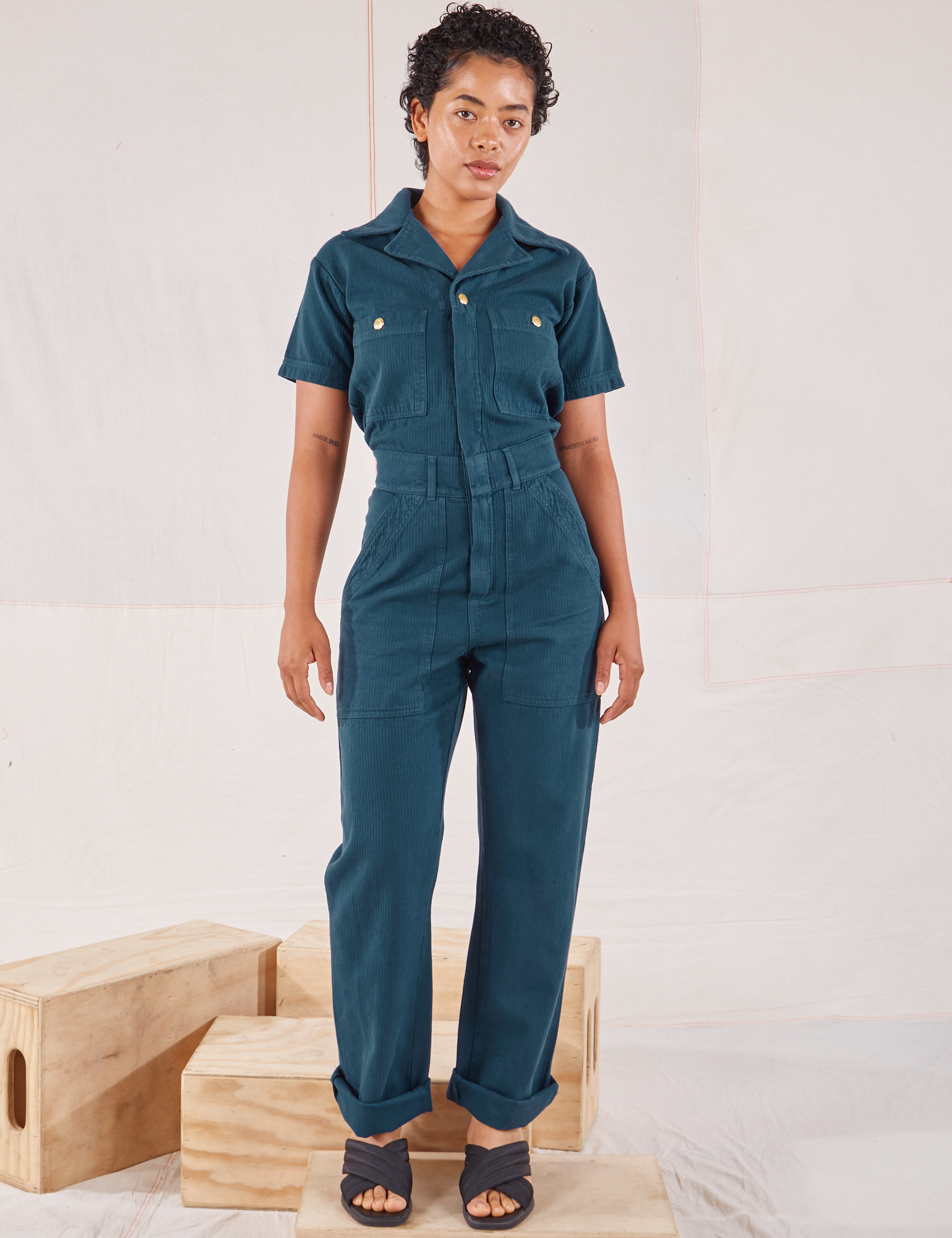 Mika is 5’1” and wearing XXS Heritage Short Sleeve Jumpsuit in Lagoon