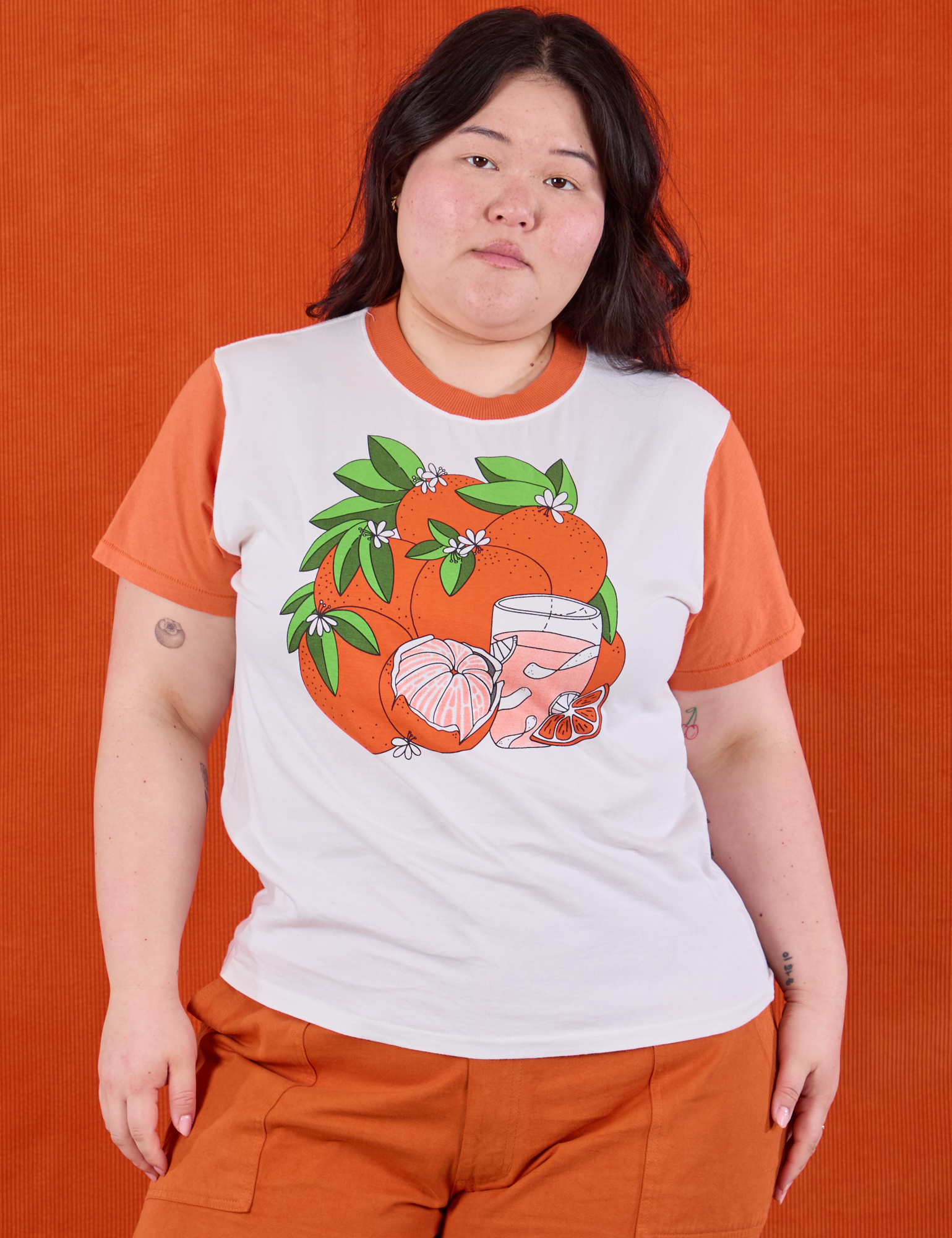 Ashley is 5’7” and wearing L Anniversary Tee in Orange Blossom