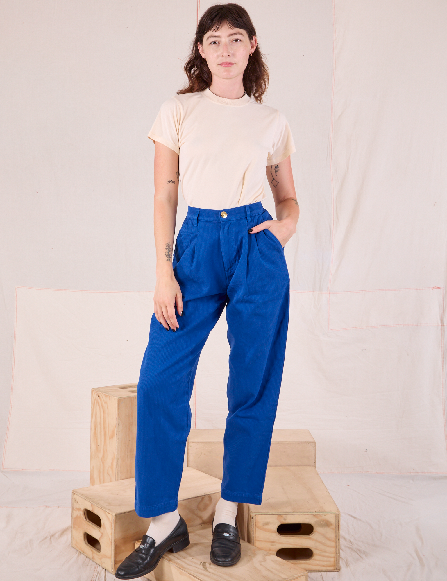 Alex is 5’8” and wearing XXS Heritage Trousers in Royal Blue paired with a Organic Vintage Tee in vintage tee off-white