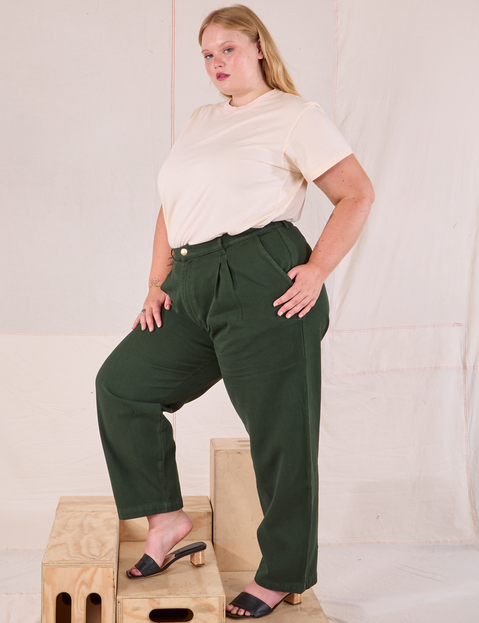 Side view of Heritage Trousers in Swamp Green and Organic Vintage Tee in vintage tee off-white on Juliet