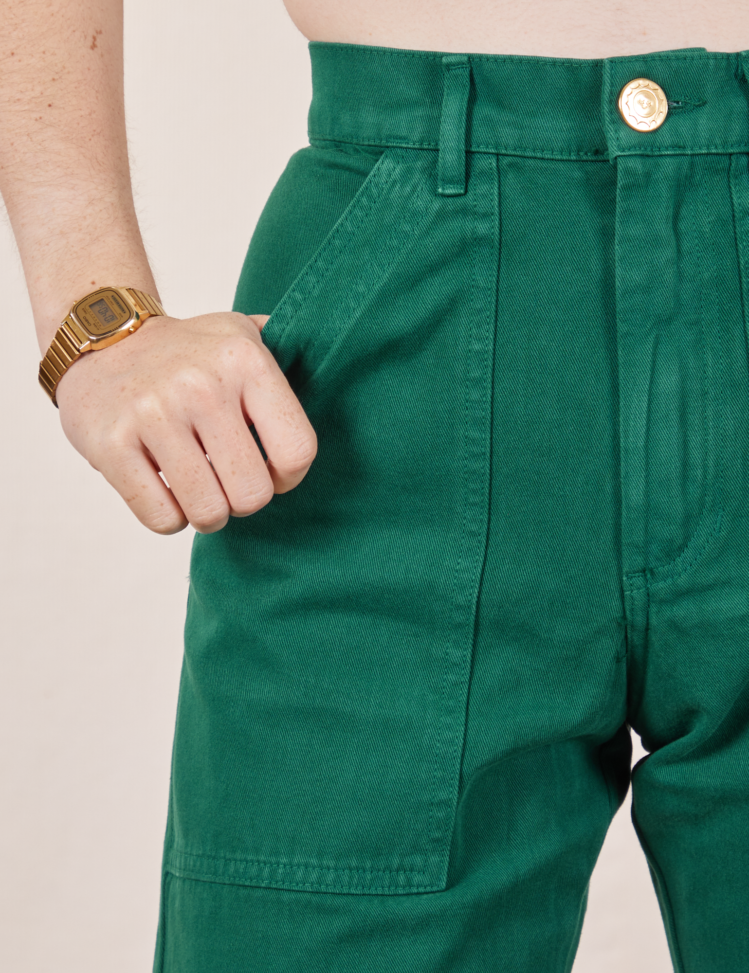 Front pocket close up of Work Pants in Hunter Green. Hana has her hand in the pocket