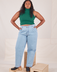 Meghna is 5'8" and wearing XS Sleeveless Essential Turtleneck in Hunter Green paired with light wash Denim Trousers