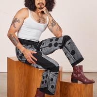 Jesse is sitting on a wooden box wearing Icon Work Pants in Dice and vintage off-white Cropped Cami