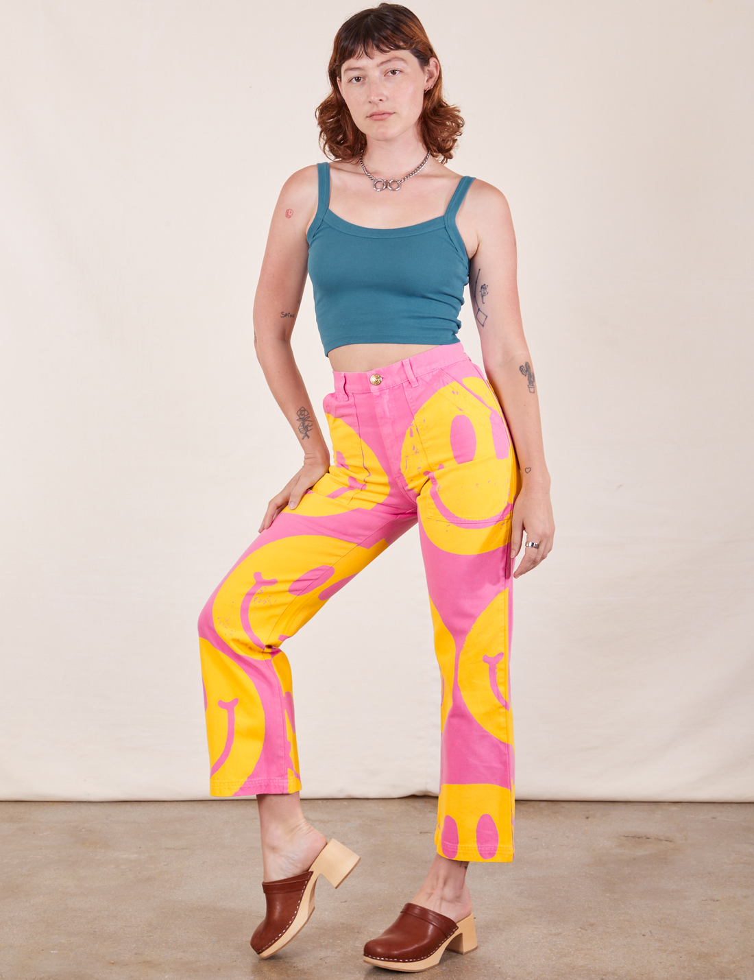 Alex is wearing Icon Work Pants in Smilies paired with marine blue Cropped Cami