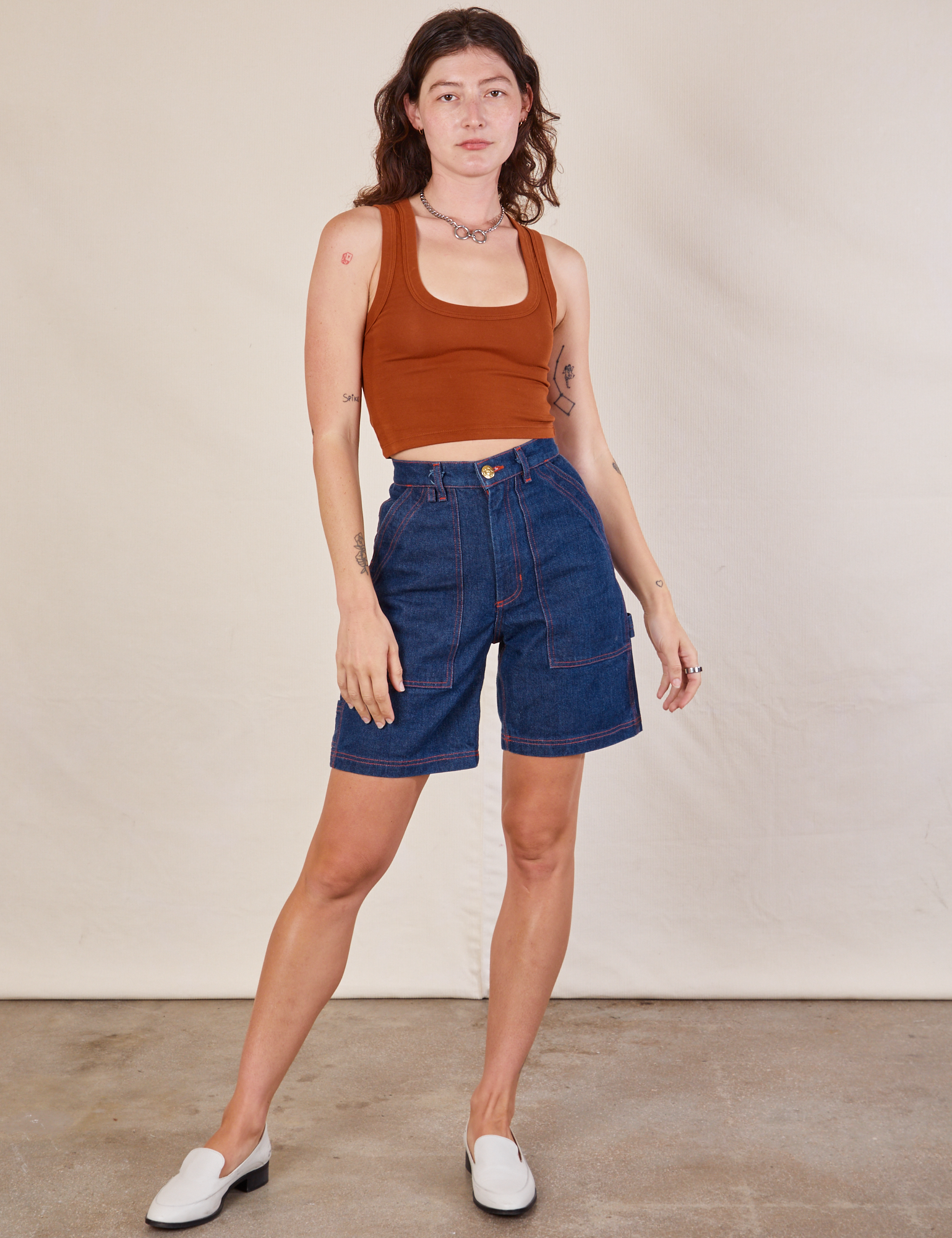Alex is 5'8" and wearing XXS Carpenter Shorts in Dark Wash paired with burnt terracotta Cropped Tank