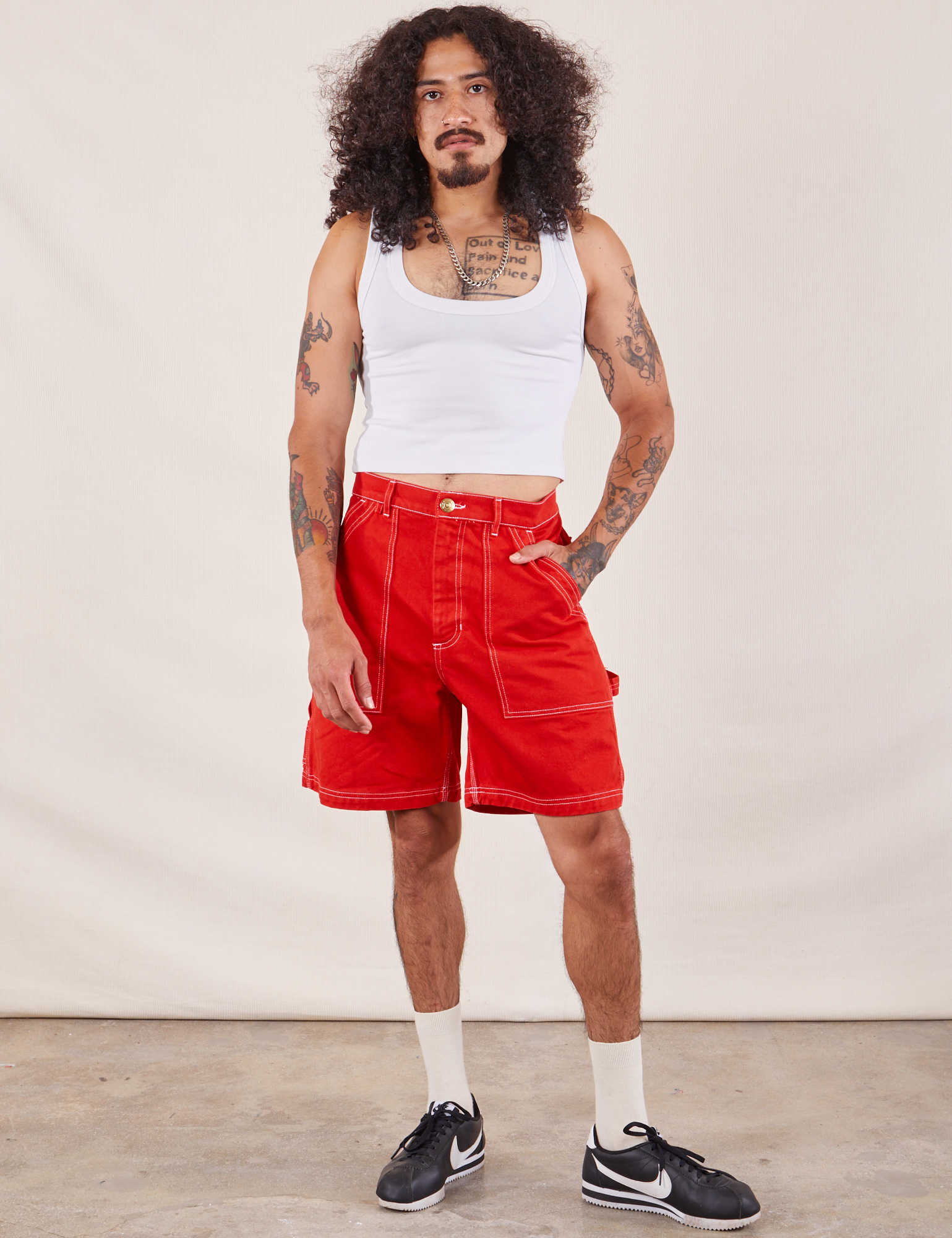 Jesse is 5'8" and wearing S Carpenter Shorts in Mustang Red paired with a Cropped Tank in vintage tee off-white