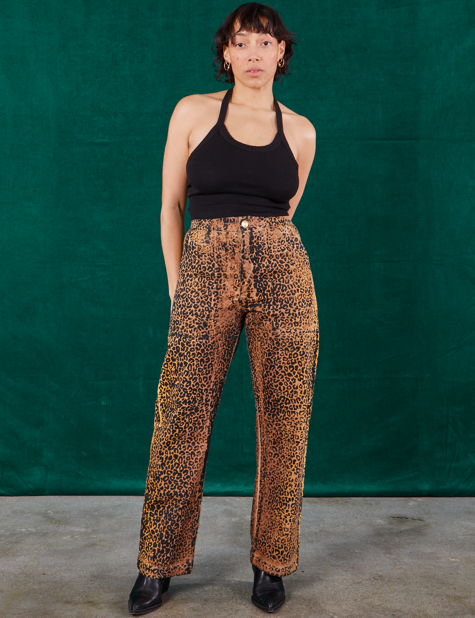 Tiara is 5'4" and wearing S Leopard Work Pants paired with black Halter Top