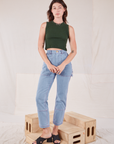 Alex is wearing Muscle Tee in Swamp Green and light wash Carpenter Jeans