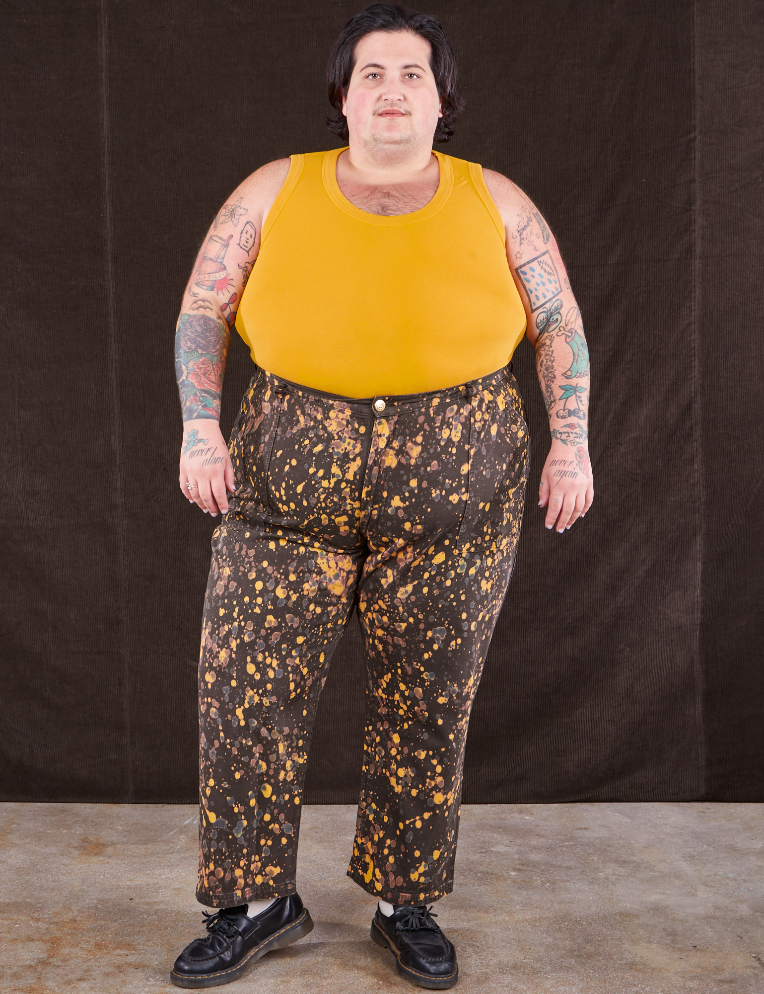 Sam is 5&#39;10&quot; and wearing 3XL Marble Splatter Work Pants in Espresso Brown paired with mustard yellow Tank Top