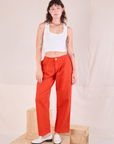 Alex is wearing Mid-Rise Pleated Trousers in Chili Red and Cropped Tank in Vintage Tee Off-White