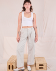 Alex is wearing Mid-Rise Pleated Trousers in Stone White and Cropped Tank in vintage tee off-white