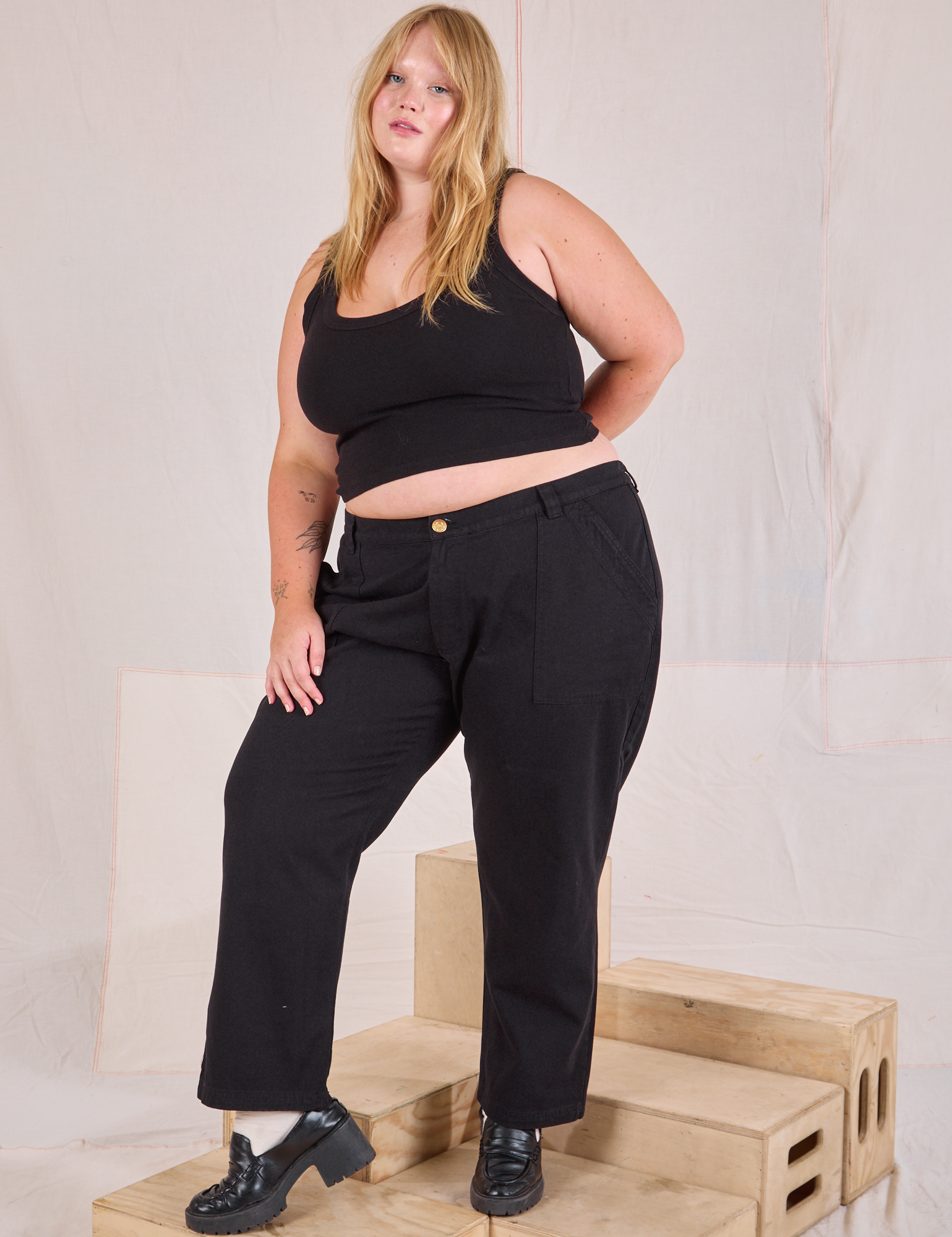 Juliet is wearing Mid-Rise Work Pants in Basic Black and black Cropped Tank