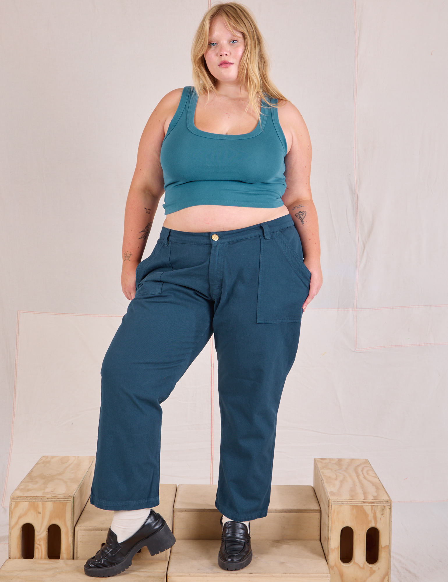 Juliet is wearing Mid-Rise Work Pants in Lagoon and marine blue Cropped Tank