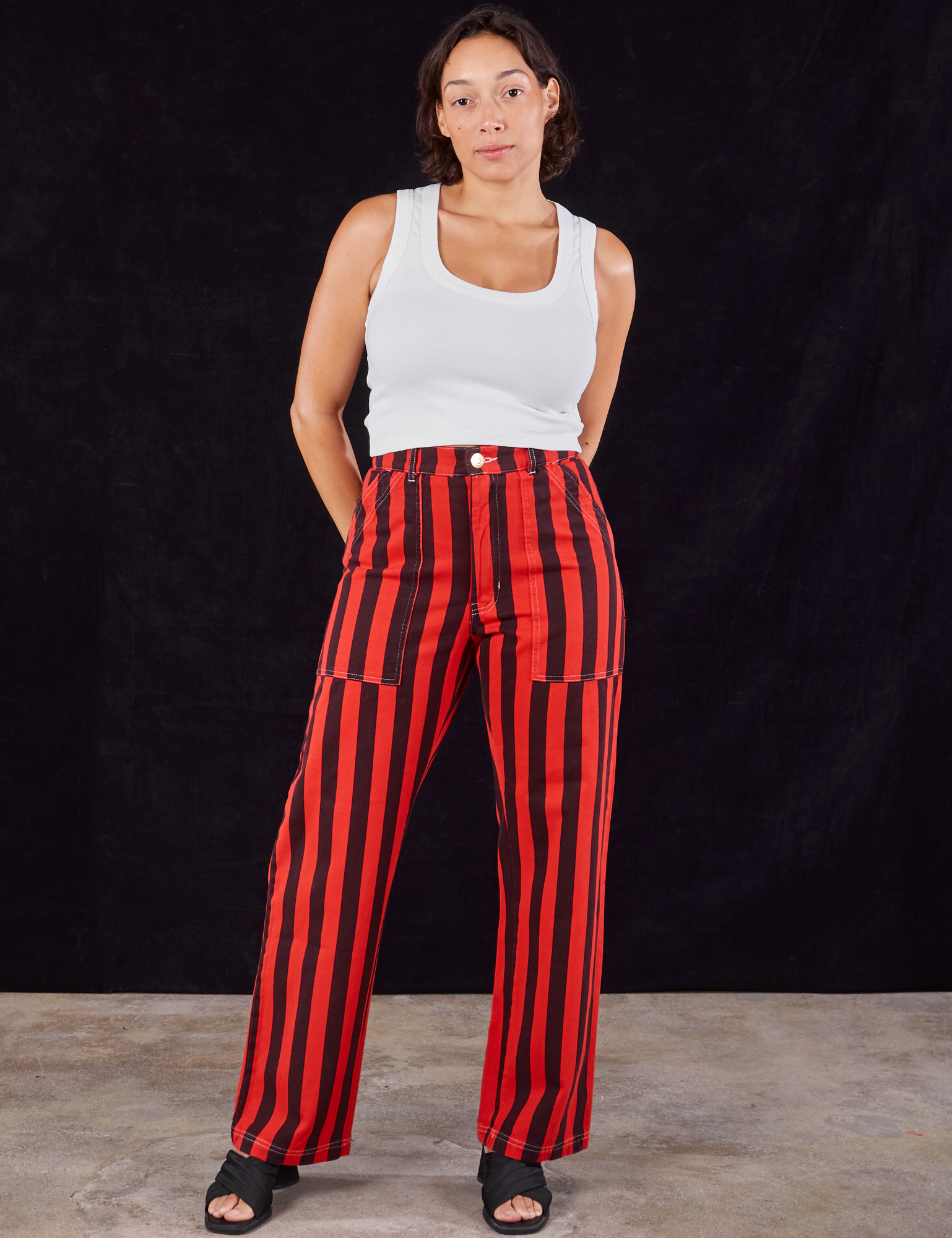 Tiara is 5'4" and wearing S Black Stripe Work Pants in Mustang Red paired with Cropped Tank in vintage tee off-white