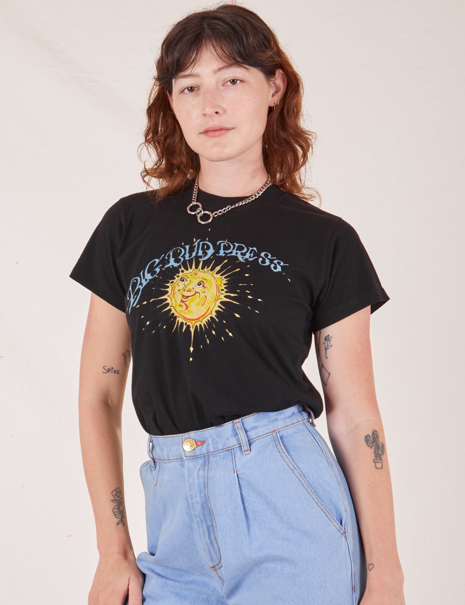 Alex is wearing Sun Baby Organic Tee in Basic Black tucked into light wash Trouser Jeans