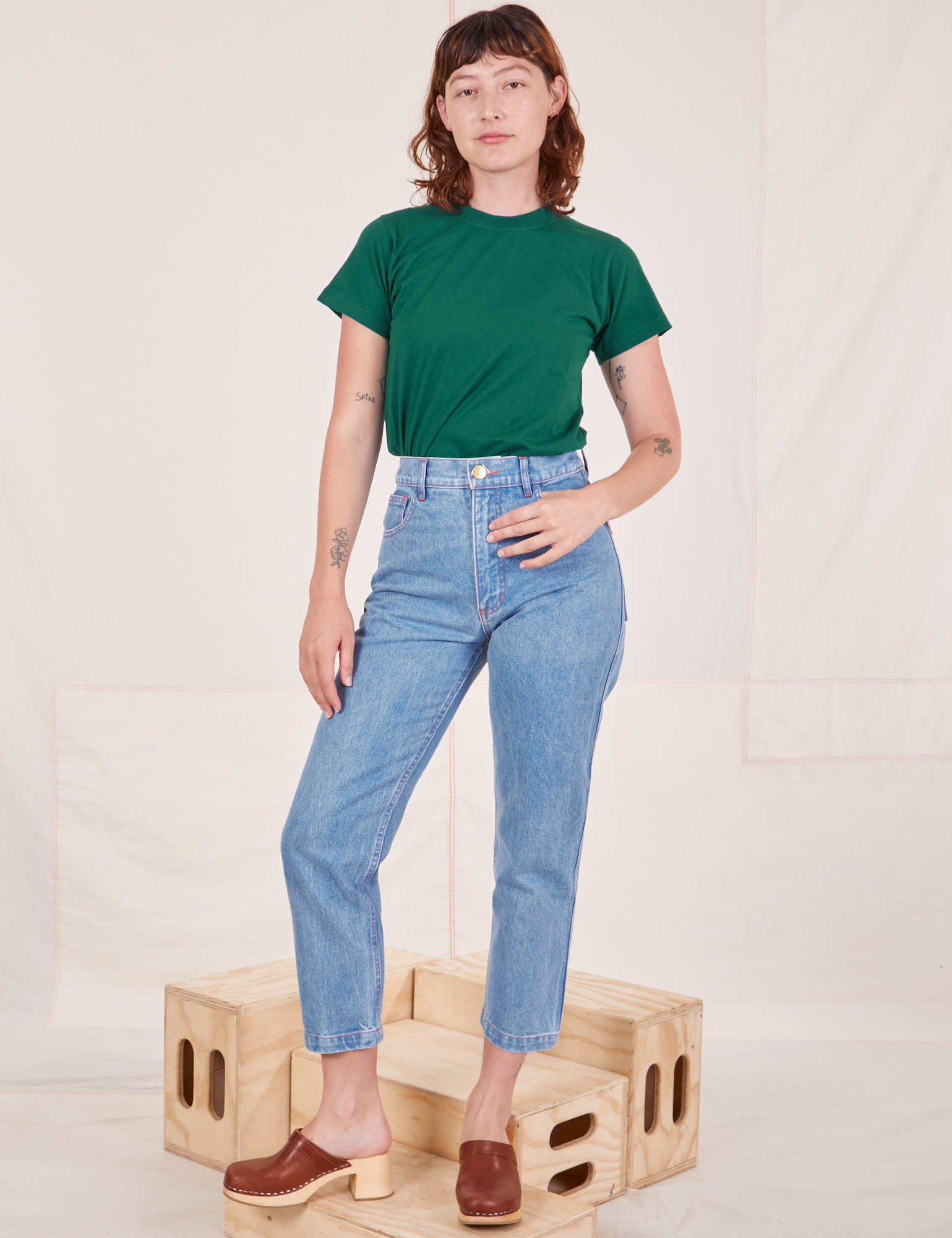 Alex is wearing Organic Vintage Tee in Hunter Green and light wash Frontier Jeans