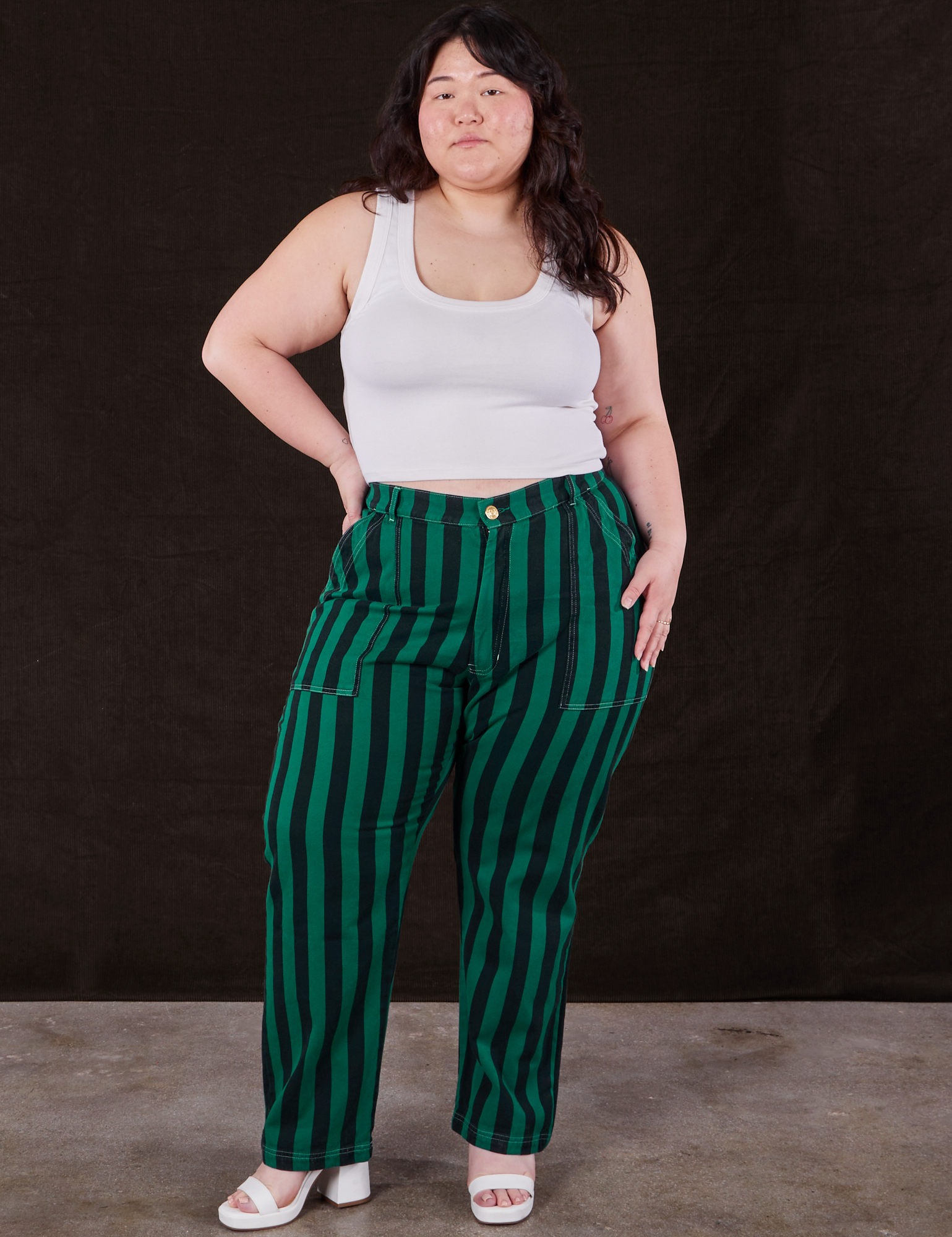 Ashley is 5’7” and wearing 1XL Black Stripe Work Pants in Hunter paired with vintage off-white Cropped Tank Top