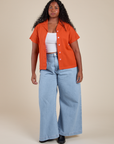 Meghna is wearing Pantry Button-Up in Chili Red and light wash Indigo Wide Leg Trousers