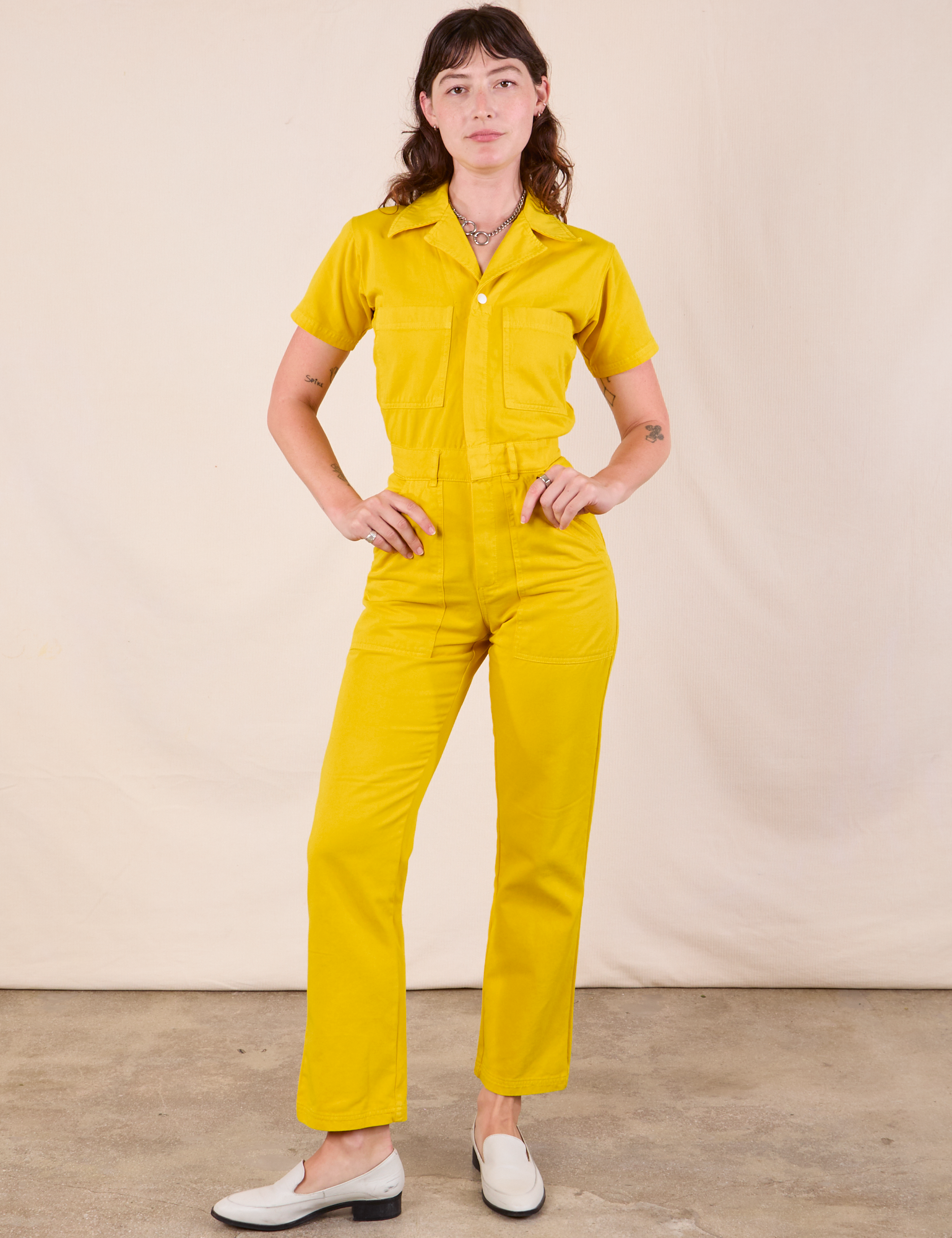 Alex is 5'8" and wearing XXS Short Sleeve Jumpsuit in Golden Yellow