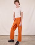 Angled front view of Work Pants in Construction Orange and Burly Tee in Vintage Tee Off-White on Quinn