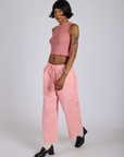 Angled front view of Drop Pocket Cargo Pants in Baby Pink and matching Muscle Tee on Kira