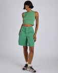Kira is wearing Longline Work Shorts in Seafoam Green and matching muscle tee