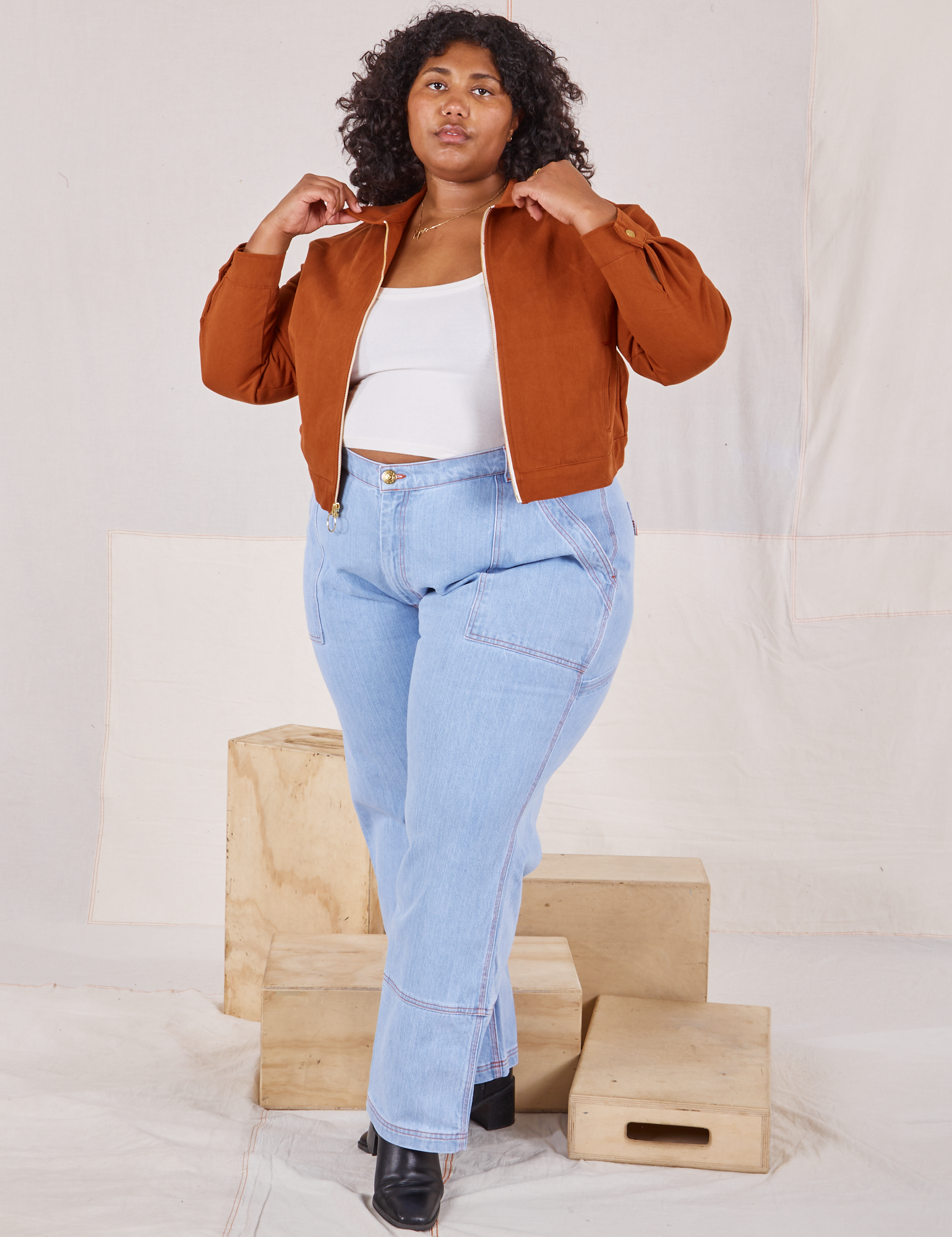 Morgan is wearing Ricky Jacket in Burnt Terracotta with a vintage off-white cami and light wash Carpenter Jeans