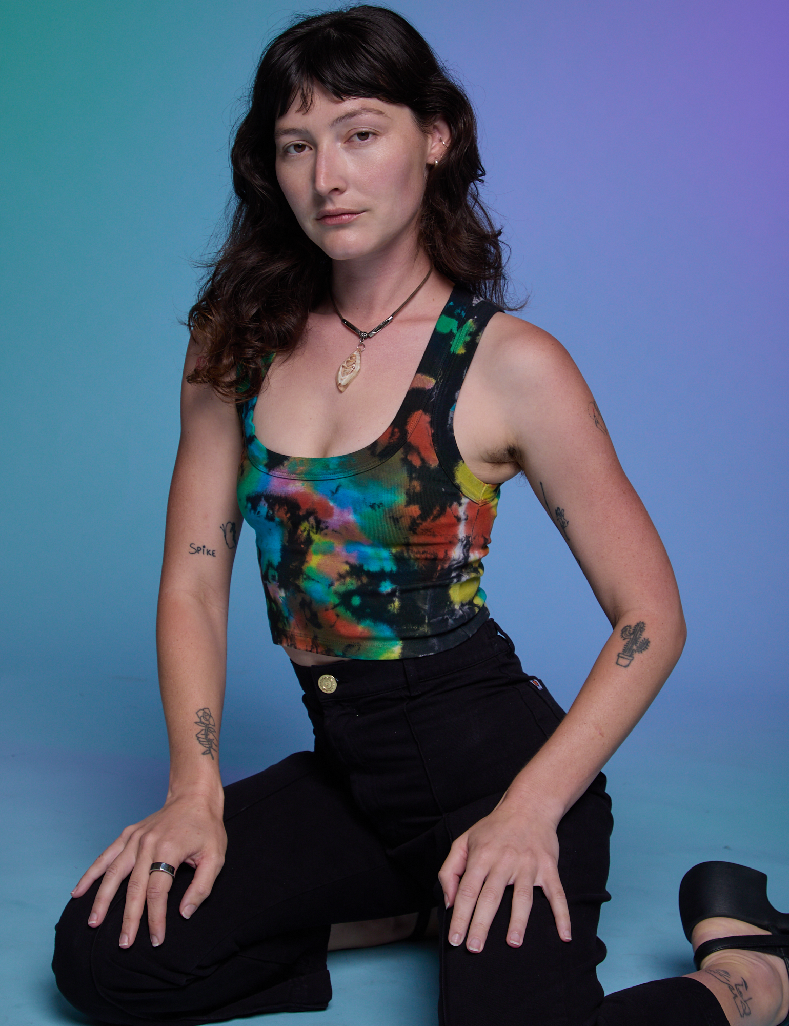 Alex is wearing Rainbow Magic Waters Cropped Tank and black Work Pants